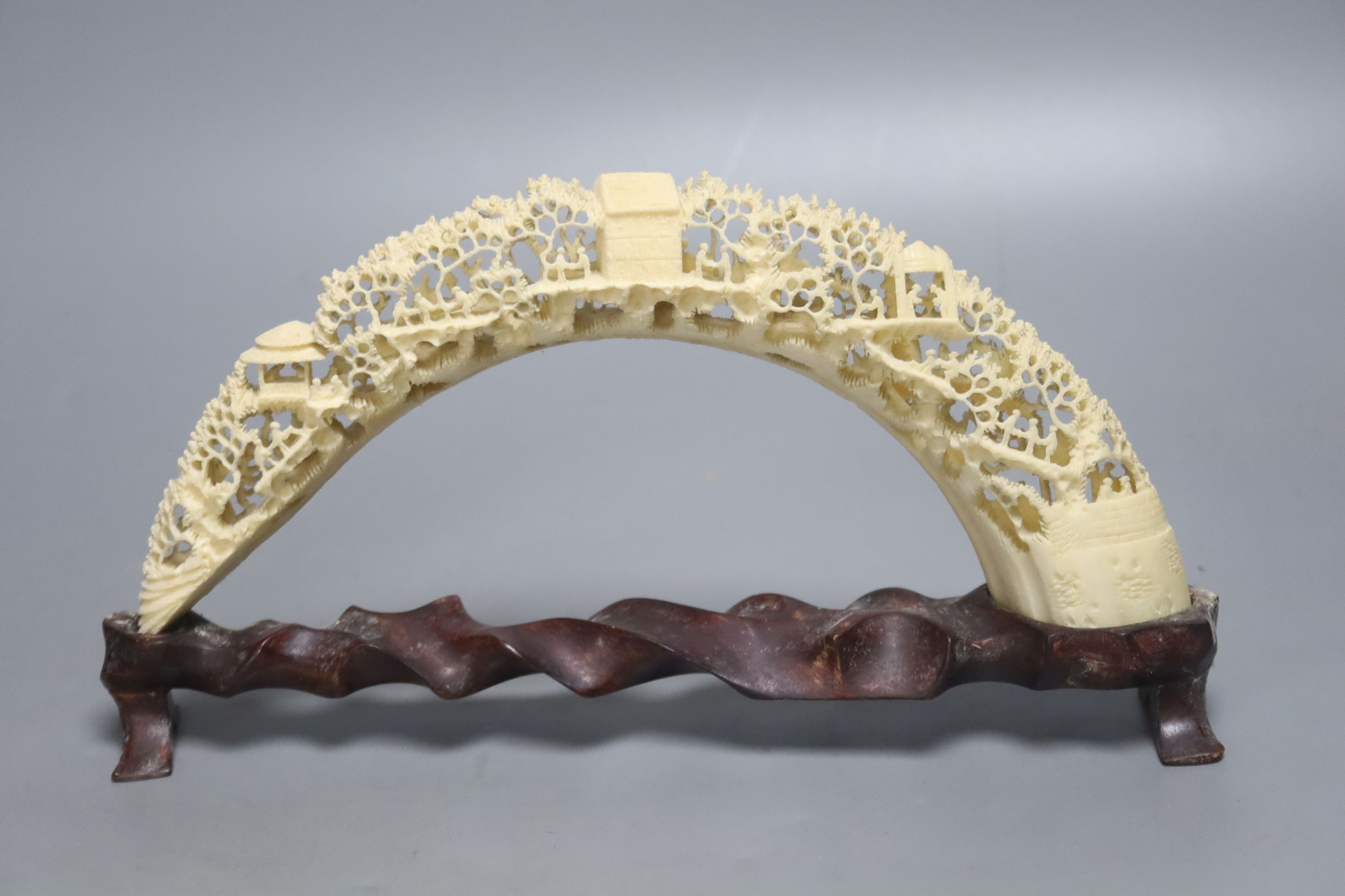 A 20th century Chinese carved and pierced boar’s tusk decorated with trees, 27cm wide